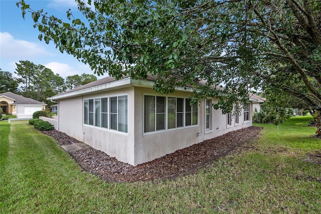 view of home's exterior featuring a garage and a lawn