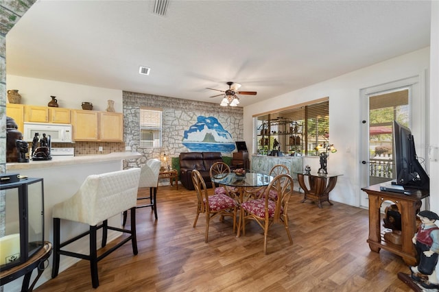 dining room with ceiling fan and hardwood / wood-style flooring