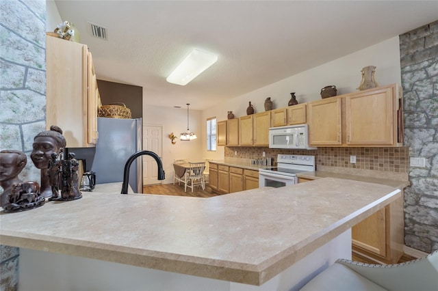 kitchen with decorative backsplash, white appliances, light brown cabinetry, and kitchen peninsula