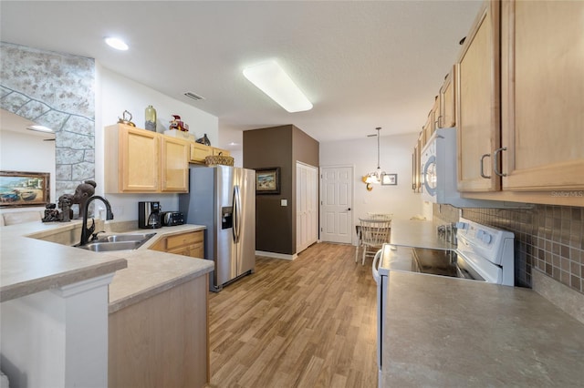 kitchen featuring hanging light fixtures, white appliances, light brown cabinets, light hardwood / wood-style flooring, and sink