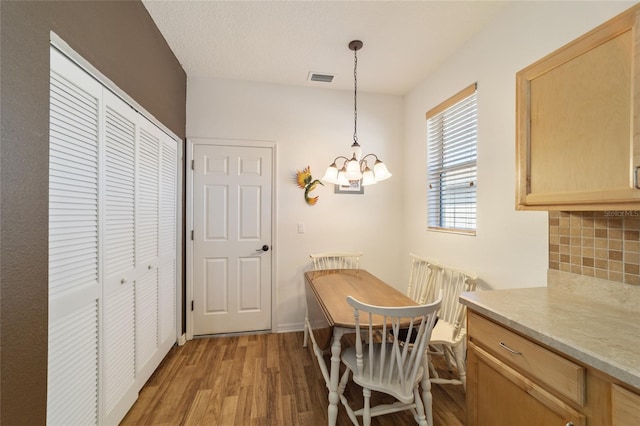 dining area featuring hardwood / wood-style flooring and a notable chandelier