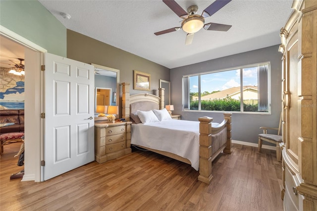 bedroom with ceiling fan, a textured ceiling, and light hardwood / wood-style floors