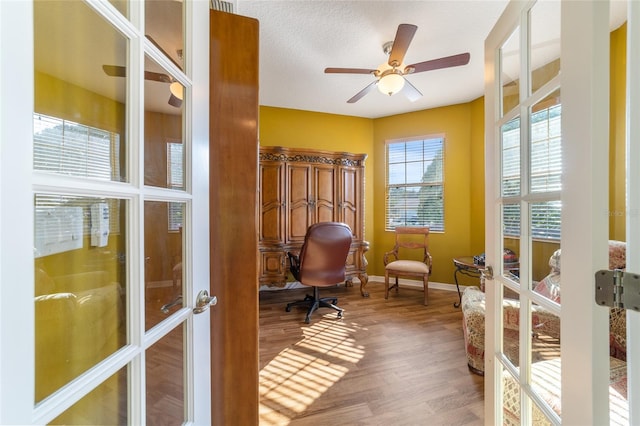 office space with a textured ceiling, wood-type flooring, ceiling fan, and french doors