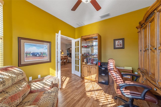 office area featuring ceiling fan, a textured ceiling, light wood-type flooring, and french doors