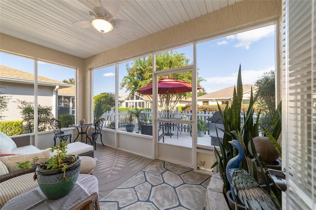 sunroom with ceiling fan and wooden ceiling