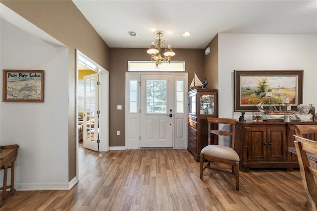 foyer featuring wood-type flooring and an inviting chandelier