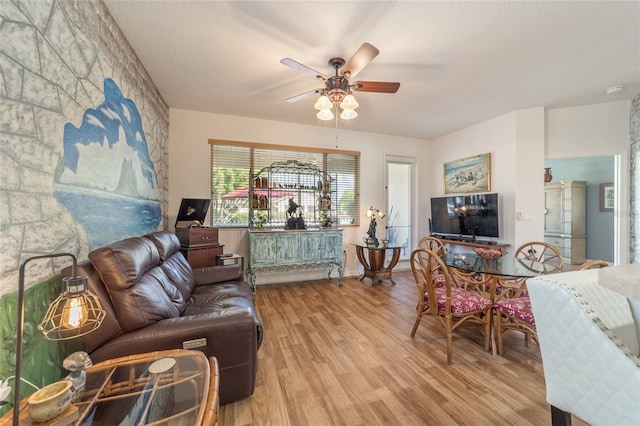 living room featuring a textured ceiling, ceiling fan, and light hardwood / wood-style flooring