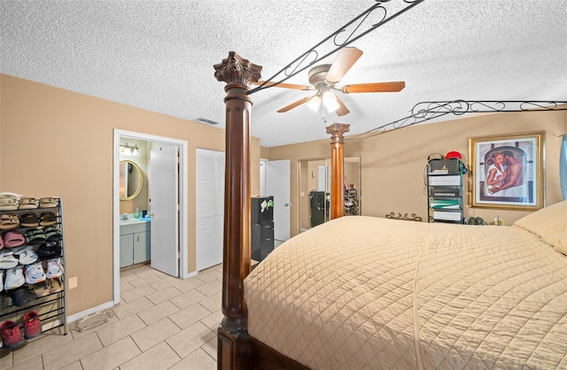 bedroom featuring ensuite bath, a textured ceiling, and ceiling fan