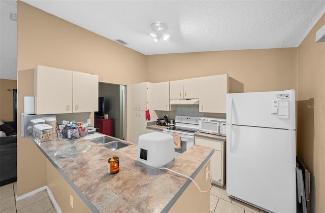 kitchen featuring light tile patterned floors, white cabinetry, vaulted ceiling, sink, and white appliances