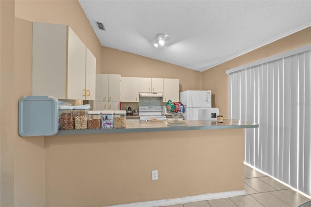 kitchen with vaulted ceiling, light tile patterned floors, white cabinetry, a textured ceiling, and white appliances