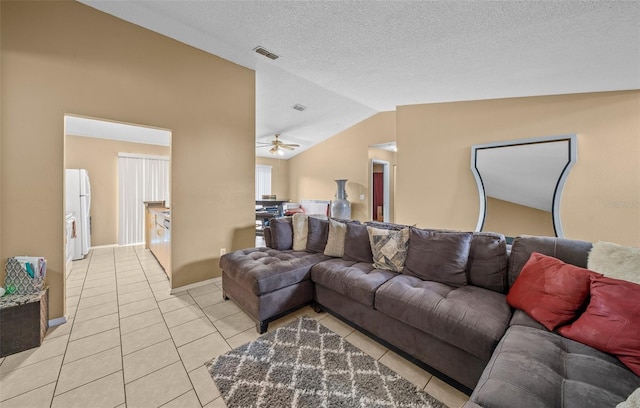 living room featuring lofted ceiling, light tile patterned flooring, and ceiling fan