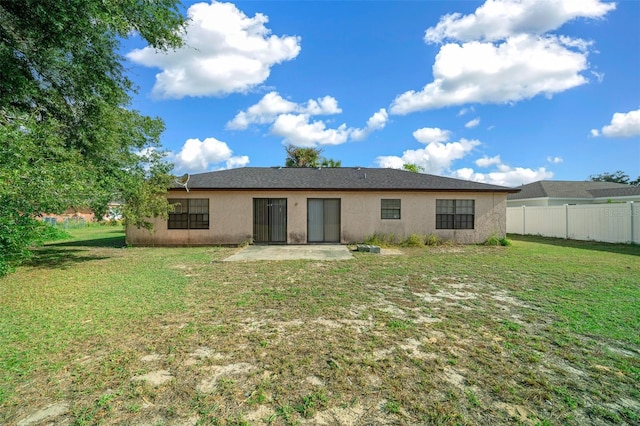 rear view of property featuring a yard and a patio area