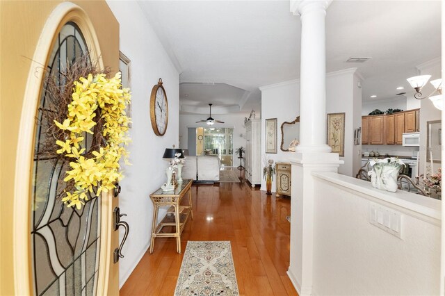 interior space featuring ornamental molding, hardwood / wood-style floors, ceiling fan, and ornate columns