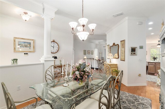 dining room featuring ceiling fan with notable chandelier, ornamental molding, light hardwood / wood-style flooring, and ornate columns