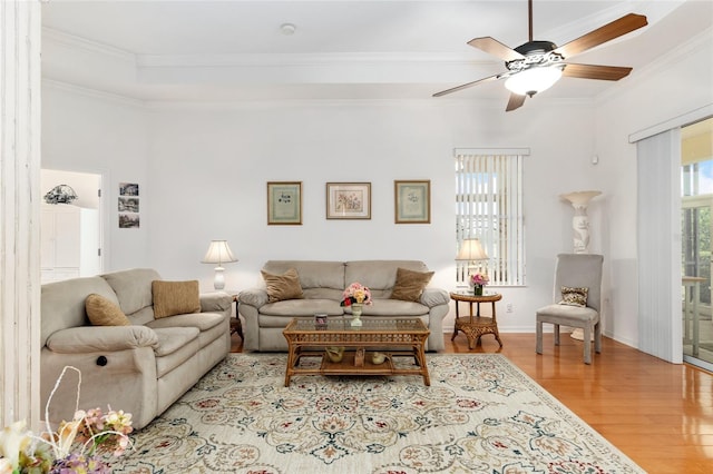 living room with ornamental molding, ceiling fan, and light hardwood / wood-style flooring