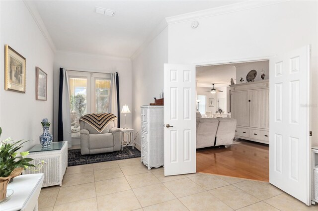 foyer with ornamental molding, ceiling fan, and light tile patterned floors