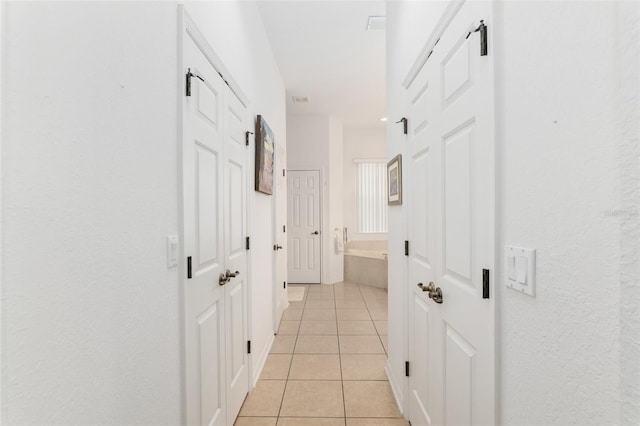 hall featuring light tile patterned floors