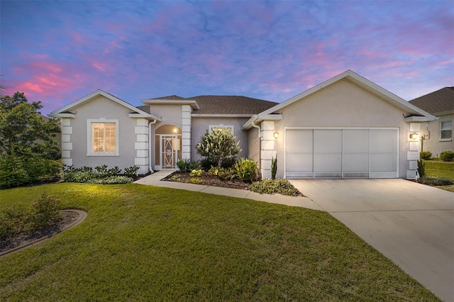 ranch-style house featuring a garage and a yard