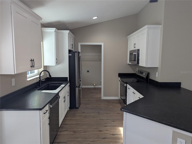 kitchen featuring white cabinetry, sink, appliances with stainless steel finishes, and vaulted ceiling