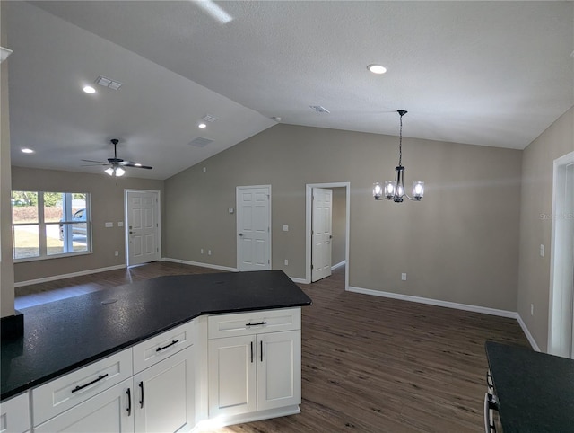 kitchen featuring white cabinets, ceiling fan with notable chandelier, vaulted ceiling, dark hardwood / wood-style floors, and decorative light fixtures