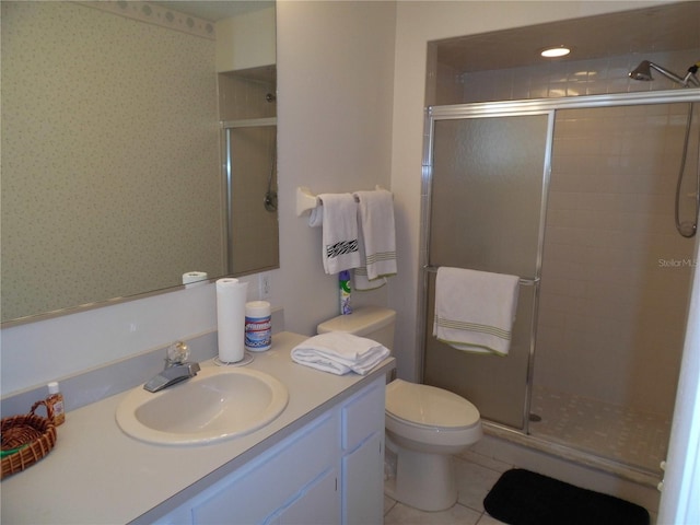 bathroom with vanity, toilet, tile patterned floors, and a shower with shower door