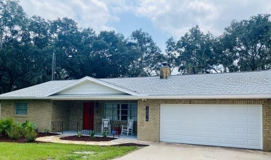 single story home with a porch and a garage