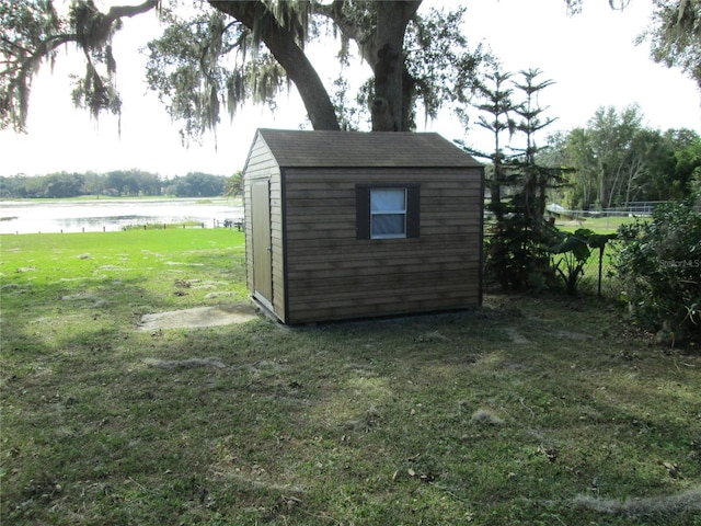 view of outdoor structure with a lawn and a water view