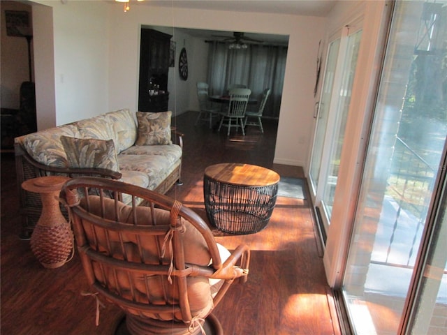 living room featuring ceiling fan and dark hardwood / wood-style floors