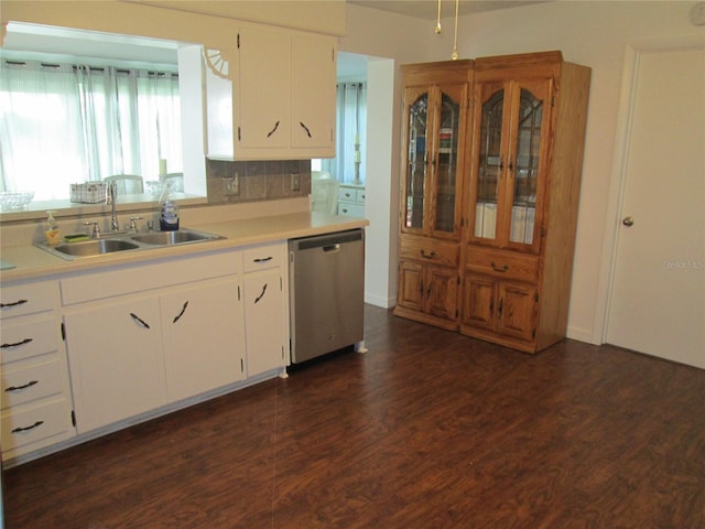 kitchen with white cabinets, sink, stainless steel dishwasher, dark hardwood / wood-style flooring, and decorative backsplash