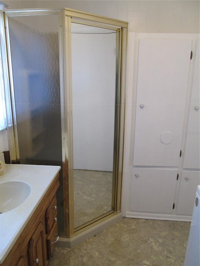 bathroom with walk in shower and vanity