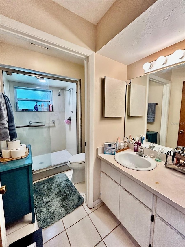 bathroom with tile patterned floors, a textured ceiling, vanity, toilet, and a shower with shower door