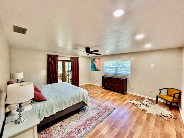 bedroom with ceiling fan, french doors, and light hardwood / wood-style flooring