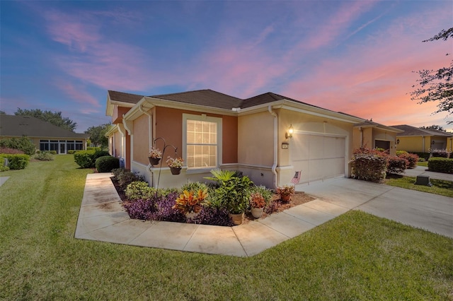 ranch-style house with a garage and a yard