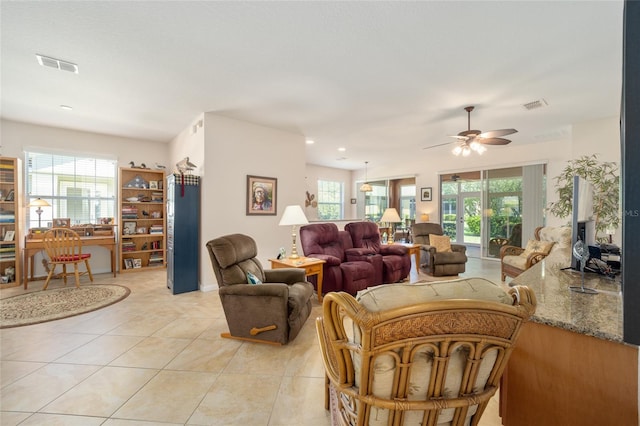 living room featuring light tile patterned flooring, ceiling fan, and a wealth of natural light