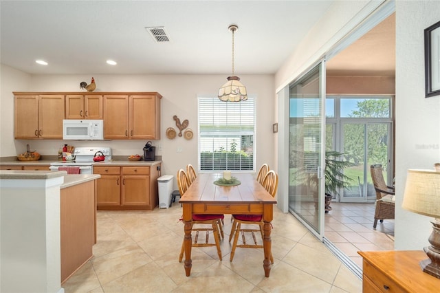 kitchen featuring pendant lighting, light tile patterned flooring, and white appliances