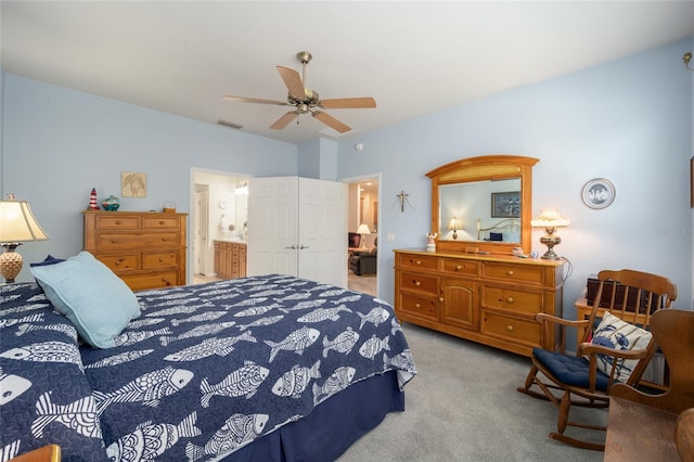 bedroom featuring ceiling fan, connected bathroom, and light carpet