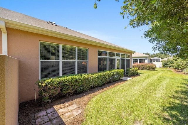 back of property with a yard and a sunroom