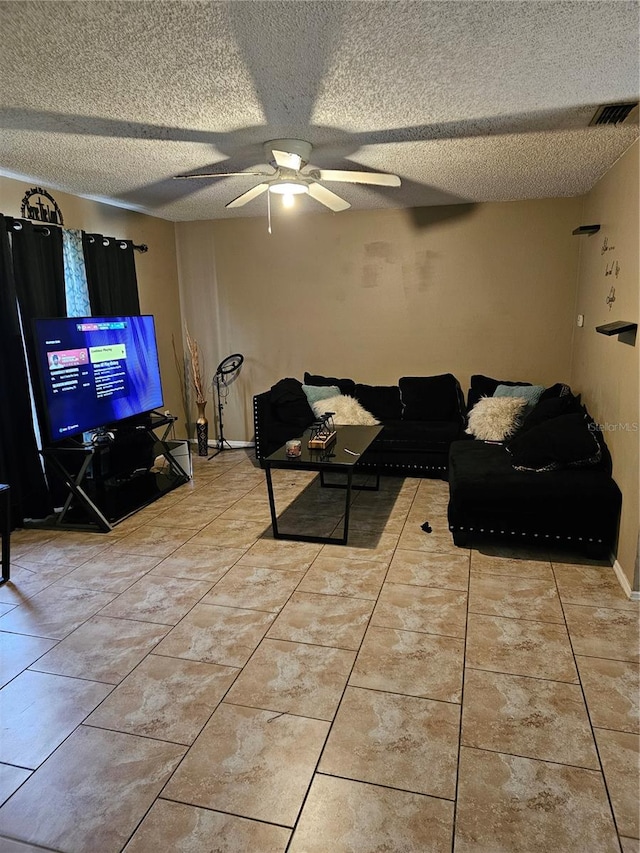 living room featuring ceiling fan and a textured ceiling