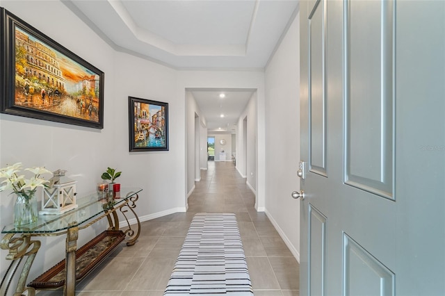 corridor with a raised ceiling and light tile patterned floors