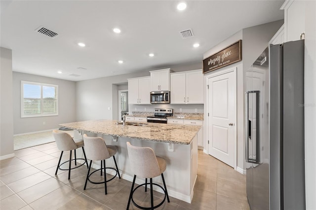 kitchen with a center island with sink, sink, white cabinetry, and stainless steel appliances