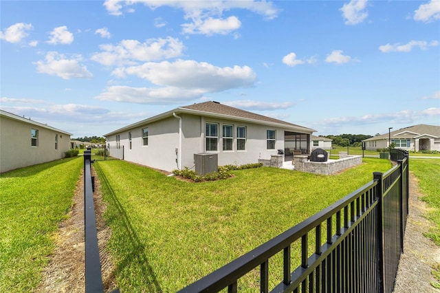 back of property featuring central AC unit and a yard