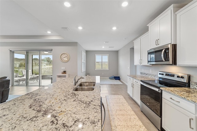 kitchen featuring white cabinets, light tile patterned floors, stainless steel appliances, and sink