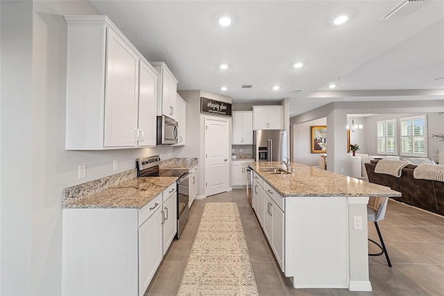 kitchen with white cabinets, a spacious island, sink, and appliances with stainless steel finishes