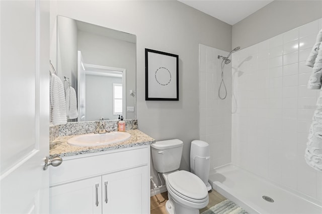 bathroom with vanity, toilet, and a shower