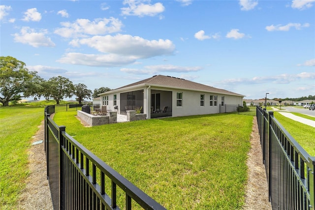 rear view of property with a sunroom and a yard