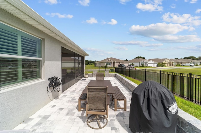 view of patio / terrace featuring a grill and a sunroom