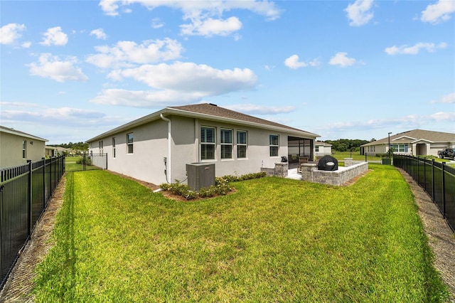 rear view of house with a lawn, cooling unit, and a patio