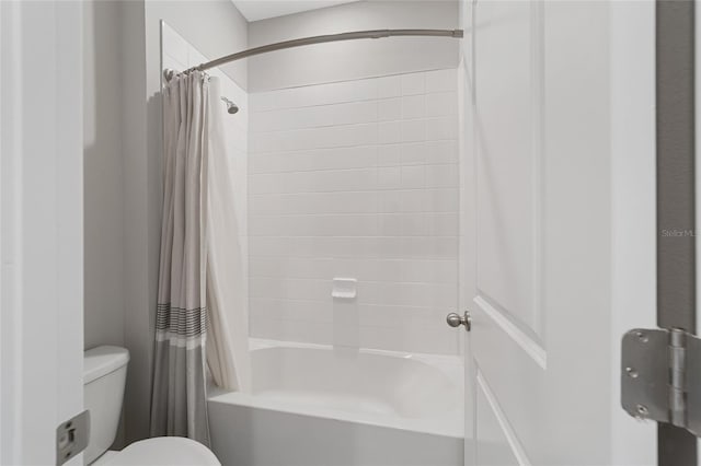 bathroom featuring toilet and shower / bath combo with shower curtain