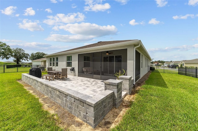 back of house with a lawn, a patio area, a sunroom, and ceiling fan