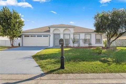 view of front of home with a front yard and a garage